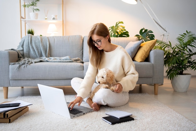 Voll erschossene Frau, die mit süßem Hund arbeitet