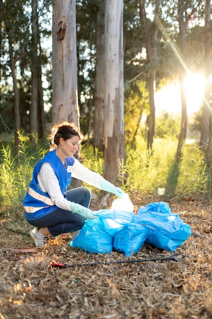 Voll erschossene Frau, die Plastikflasche sammelt