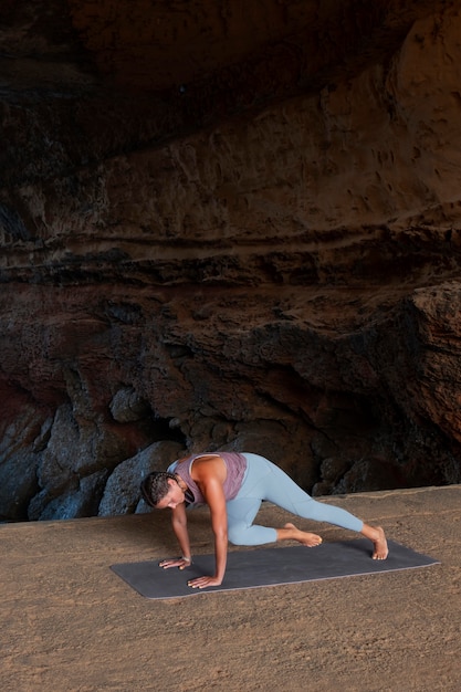 Kostenloses Foto voll erschossene frau, die yoga-pose auf matte macht