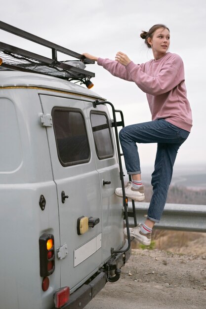 Kostenloses Foto voll erschossene frau in der nähe von van