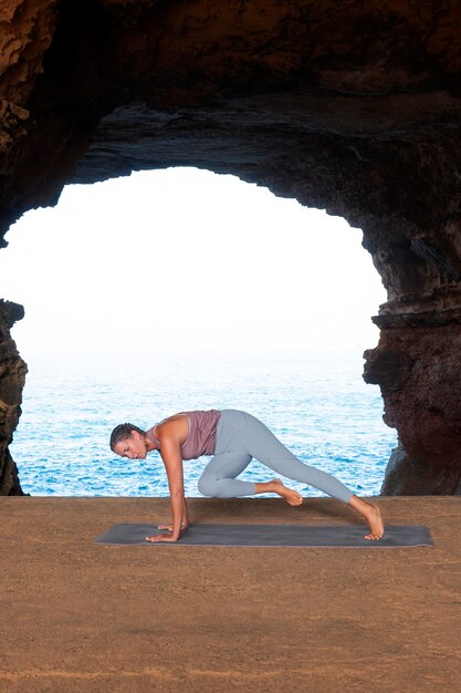 Voll erschossene Frau macht Yoga-Pose mit Aussicht