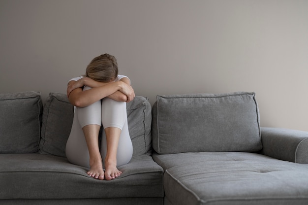 Voll erschossene Frau sitzt auf der Couch