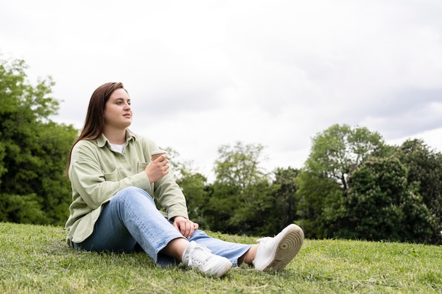 Kostenloses Foto voll erschossene frau sitzt auf gras