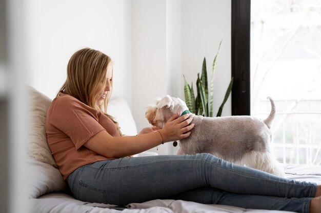 Kostenloses Foto voll erschossene frau sitzt mit hund