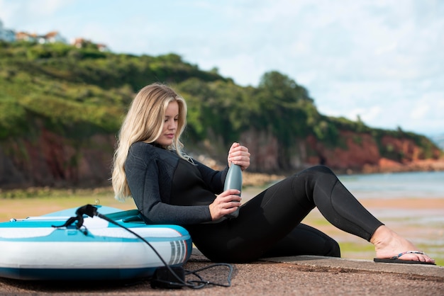 Voll erschossene Frau sitzt mit Paddleboard