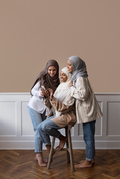 Kostenloses Foto voll erschossene frauen, die auf das telefon schauen