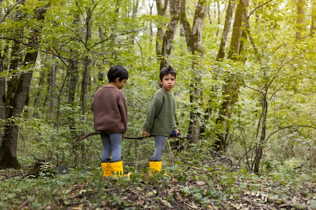 Voll erschossene Kinder, die mit Zweig spielen