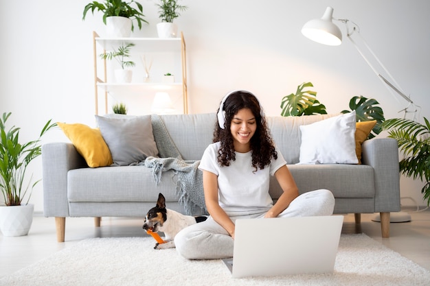 Voll erschossene Smiley-Frau auf dem Boden mit Laptop