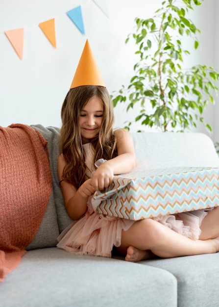 Voll erschossenes Mädchen öffnet Geschenk auf der Couch