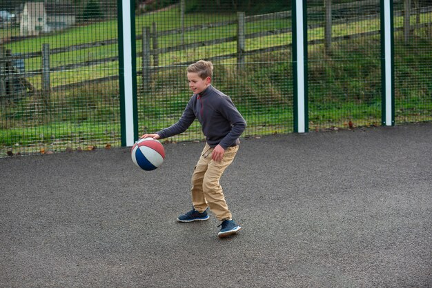 Voll geschossenes Kind, das mit Ball spielt