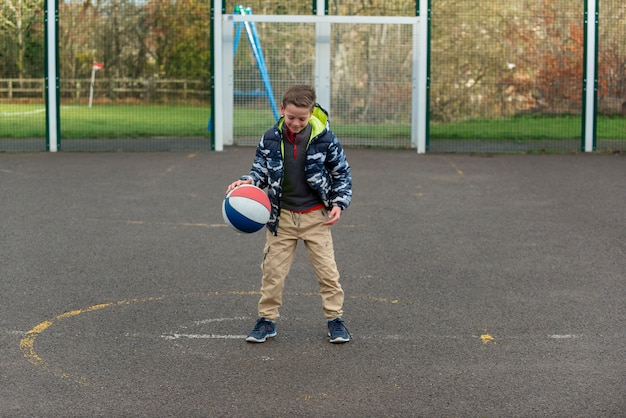 Kostenloses Foto voll geschossenes kind, das mit ball spielt