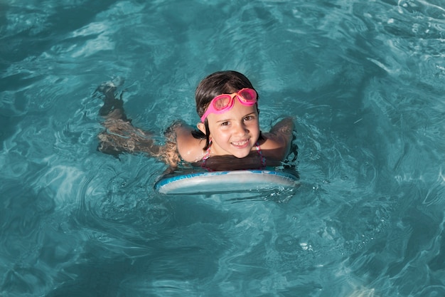 Voll geschossenes Mädchen, das mit Brille schwimmt