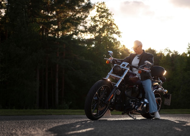 Kostenloses Foto vollbildaufnahme einer älteren frau mit motorrad