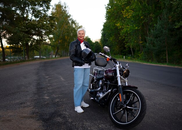 Vollbildaufnahme einer älteren Frau mit Motorrad