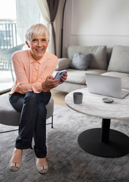 Vollbildaufnahme einer Frau, die mit dem Smartphone eine Pause macht