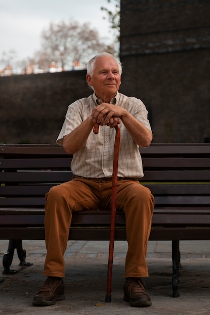 Vollbildaufnahme eines alten Mannes, der auf einer Bank sitzt