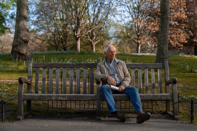 Vollbildaufnahme eines alten Mannes, der auf einer Bank sitzt