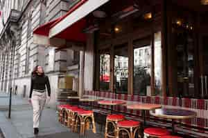 Kostenloses Foto vollbildfrau, die am bistro vorbeigeht