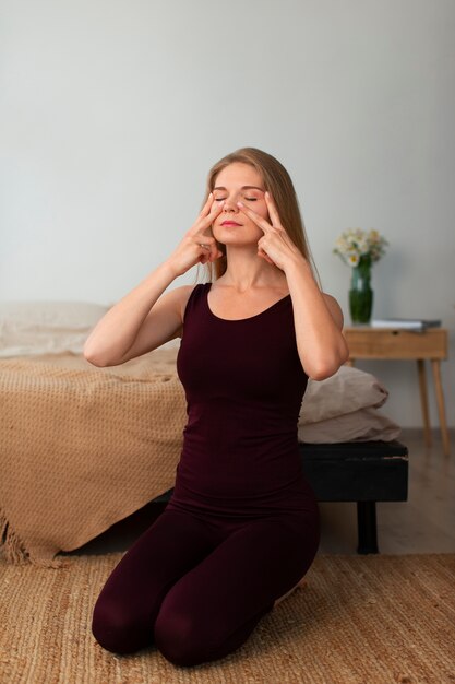 Vollbildfrau, die Gesichtsyoga praktiziert