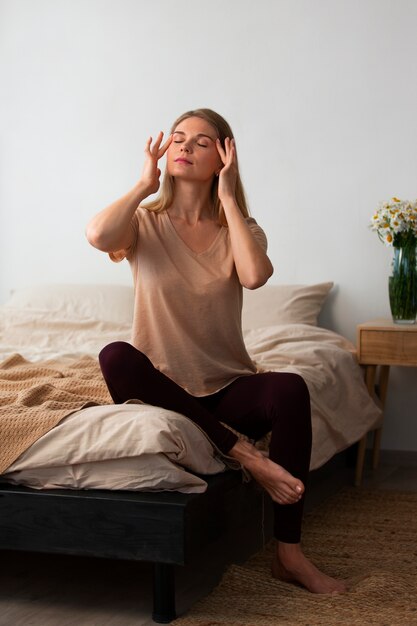 Vollbildfrau, die Gesichtsyoga praktiziert