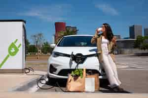 Kostenloses Foto vollbildfrau, die kaffee in der nähe des autos genießt