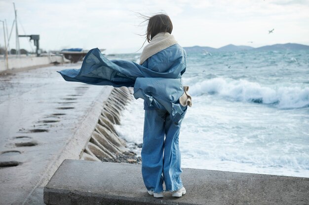 Vollbildfrau mit warmem Schal am Meer