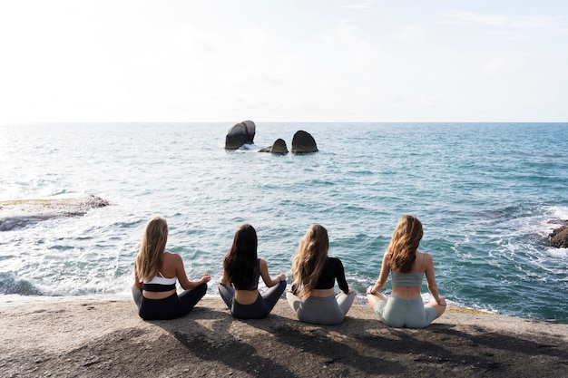 Vollbildfrauen, die am Meer meditieren