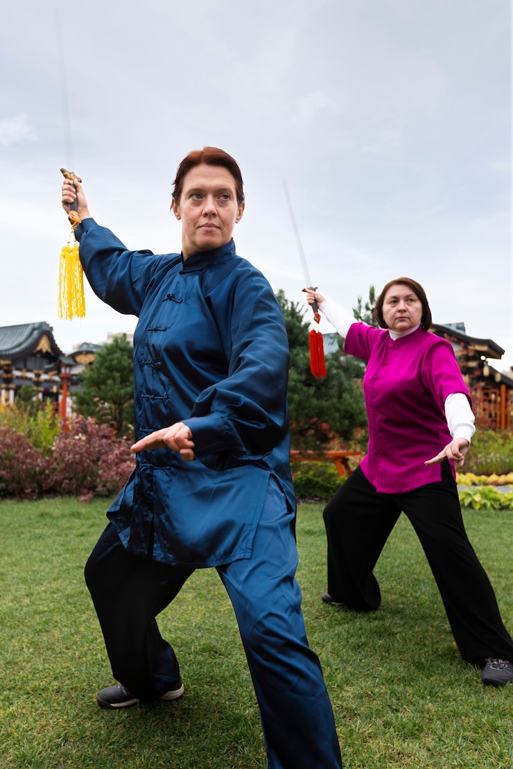 Kostenlose Foto vollbildfrauen, die im freien tai chi üben