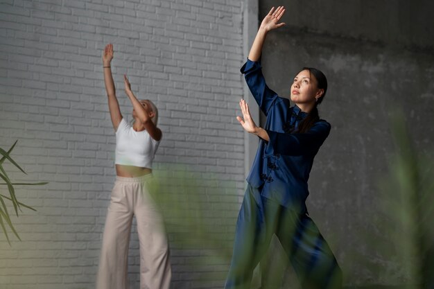 Kostenloses Foto vollbildfrauen, die zusammen tai chi üben