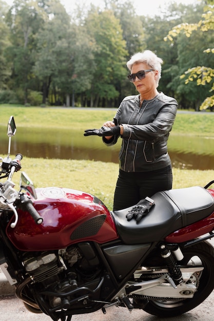 Volle Aufnahme einer alten Frau mit coolem Motorrad