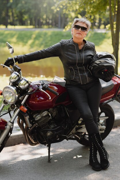 Volle Aufnahme einer alten Frau mit coolem Motorrad