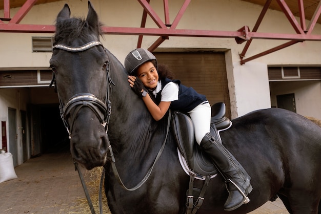 Kostenloses Foto volle aufnahme eines kindes, das reiten lernt