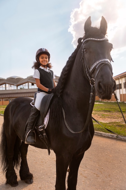 Volle Aufnahme eines Kindes, das Reiten lernt