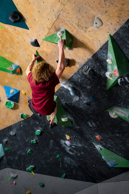 Kostenloses Foto volle aufnahme eines mannes, der an der wand klettert