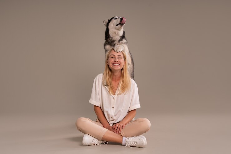 Kostenlose Foto volle aufnahme frau mit hund im studio