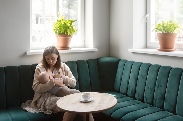 Kostenloses Foto volle aufnahme frau stillt baby drinnen