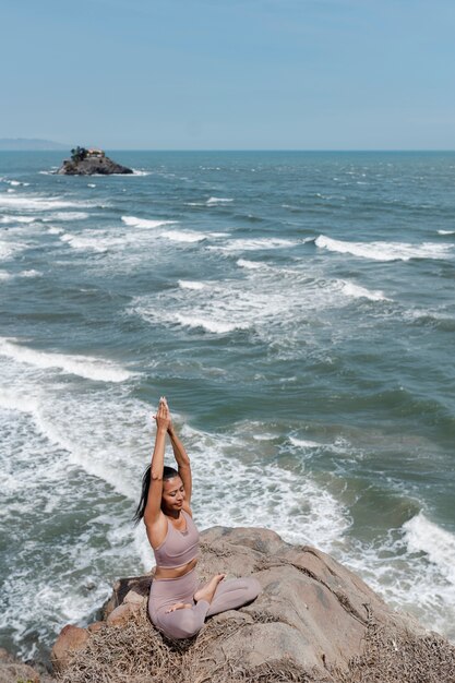 Volle Aufnahme Frau Yoga-Pose am Meer