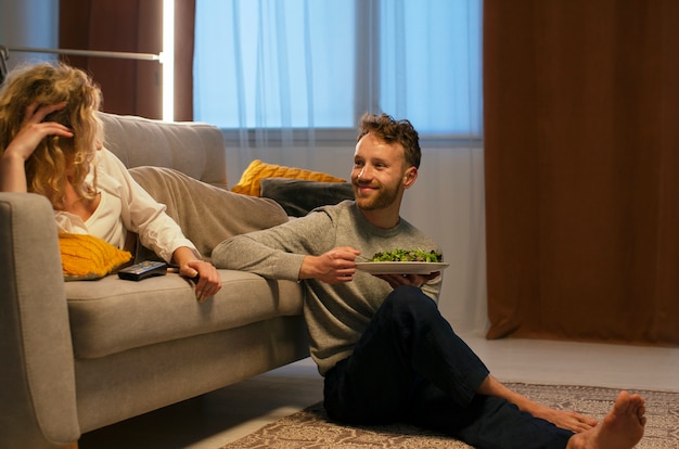 Kostenloses Foto volle aufnahme von leuten, die essen und nachrichten ansehen