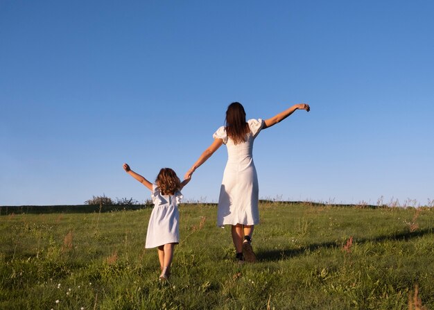 Volle Aufnahme von Mutter und Kind, die in der Natur spazieren gehen