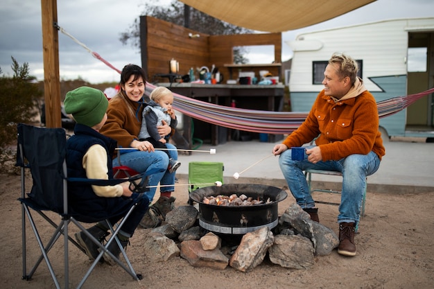 Volle glückliche Familie um Feuer