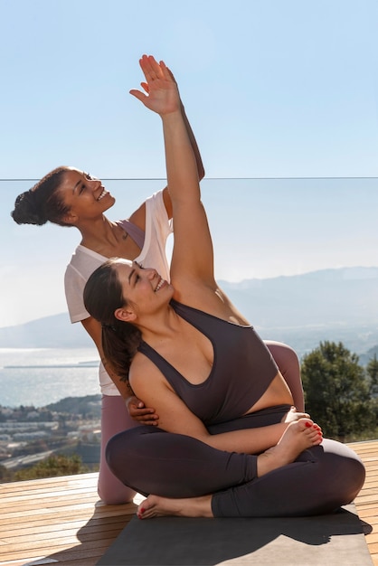 Volle Schuss glückliche Frauen, die Yoga machen