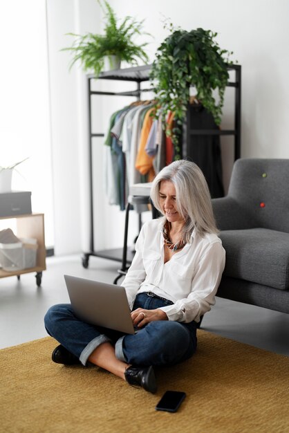 Volle Schussfrau, die an Laptop arbeitet