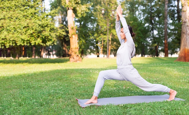 Volle Schussfrau, die auf Yogamatte ausdehnt