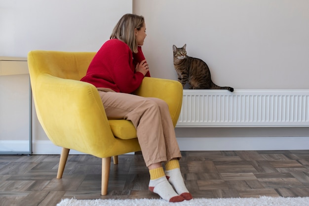 Volle Schussfrau, die Katze betrachtet