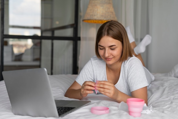 Kostenloses Foto volle schussfrau, die menstruationstasse faltet