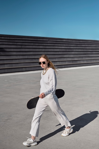 Kostenloses Foto volle schussfrau, die mit skateboard aufwirft