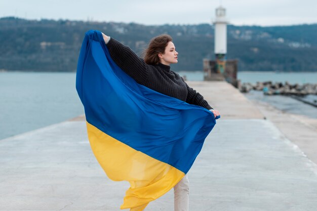 Volle Schussfrau, die ukrainische Flagge hält