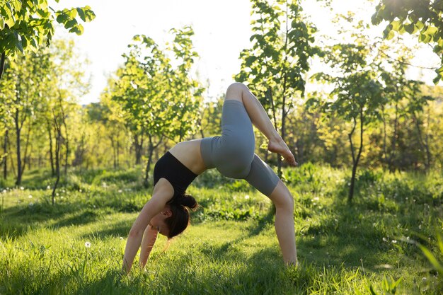 Volle Schussfrau, die Yoga in der Natur tut