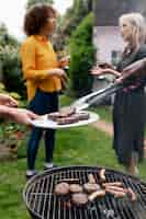 Kostenloses Foto volle schussfrauen, die nahe grill plaudern