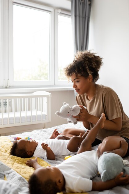 Volle Schussmutter, die mit Babys spielt